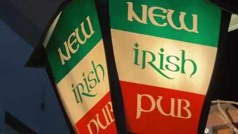 New Irish pub light up sign advertising Ireland flag at night outside bar Stock Footage 340594960