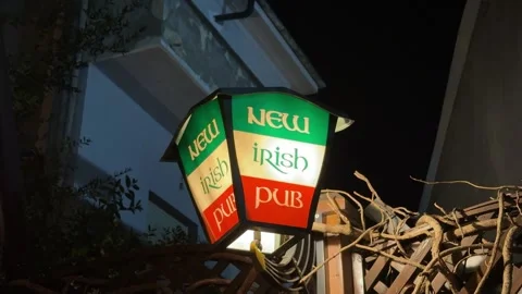 New Irish pub light up sign advertising Ireland flag at night outside bar Stock Footage 340596029