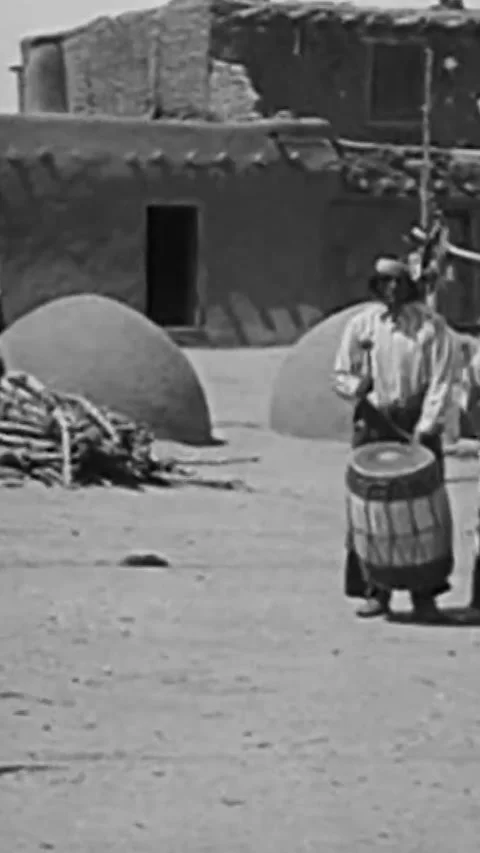 NEW MEXICO - 1919 - Native Americans dance in feathered costumes to drummers in Stock Footage 339104854