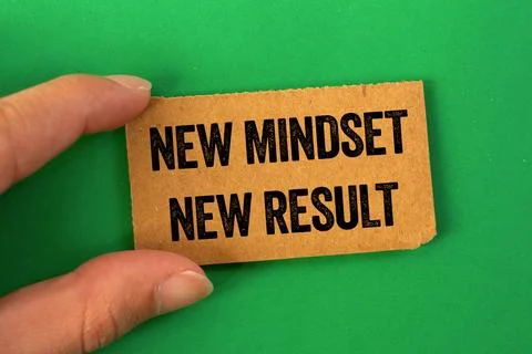 New mindset new result message written on cardboard paper on green backgrou.. Stock Photos