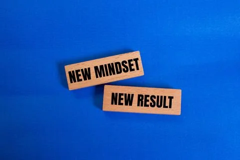 New mindset new result message written on wooden blocks on blue background... Stock Photos
