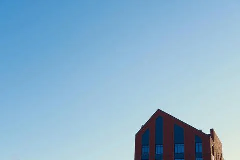 New modern brick building under clear blue sky, background with copy space Stock Photos