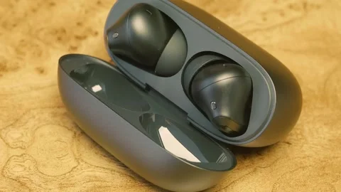 New modern high-tech earbuds with storage and charging case on glossy table Stock Footage 287945425