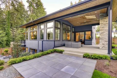 New modern home features a backyard with covered patio accented with stone fi Stock Photos
