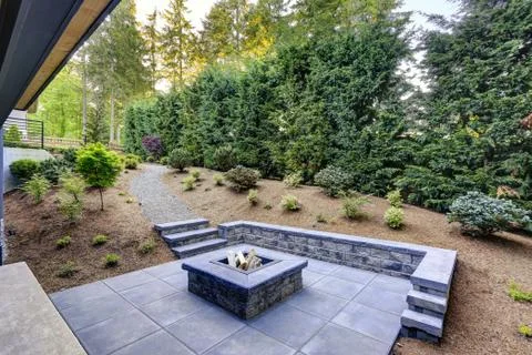 New modern home features a backyard with rectangular concrete fire pit framed Stock Photos