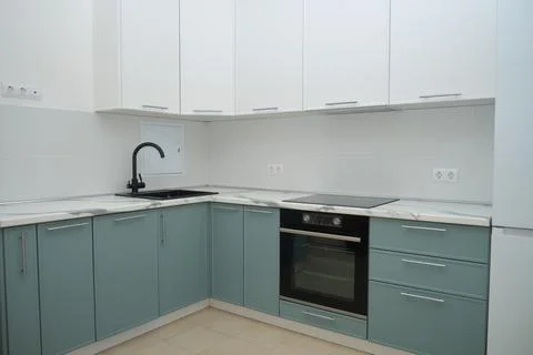 New modern kitchen interior with green cabinet and white wall. Corner kitchen Fotos Stock