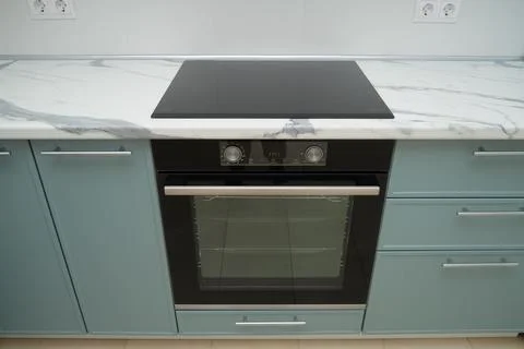 New modern kitchen interior with marble countertop, black induction cooktop a Stock Photos