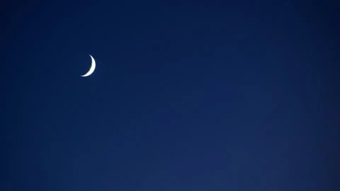 New Moon Slowly Sets through Blue Sky Time Lapse Stock Footage 281417118