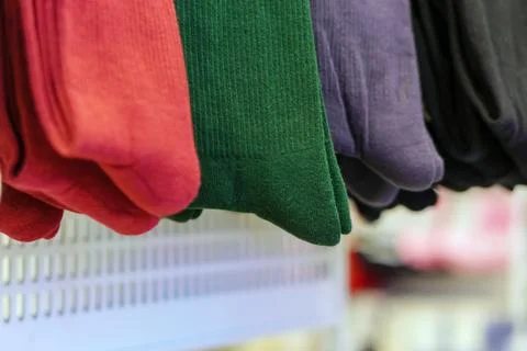 New multi-colored socks hang on a hanger in a row Stock Photos