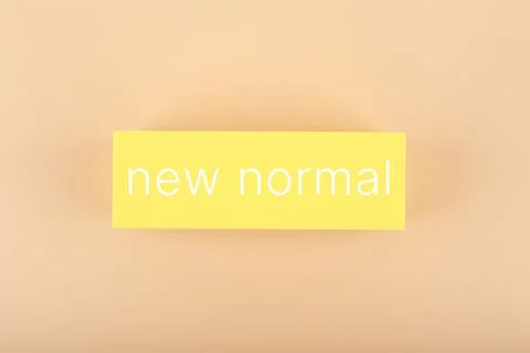 New normal concept. Text on yellow rectangle against pastel beige background Stock Photos