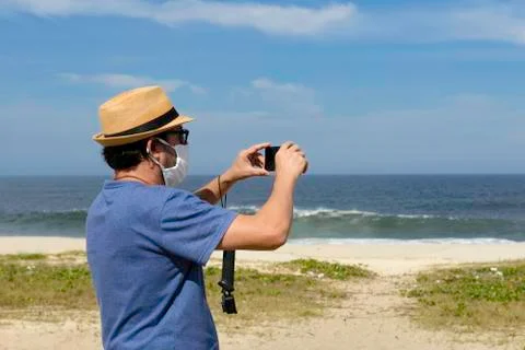 The new normal - middle-aged man takes a picture of the beach Stock Photos