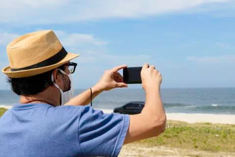 The new normal - middle-aged man takes a picture of the beach Stock-Fotos