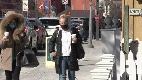 New normal with people walking down street wearing face masks in COVID pandemic Vidéo 149995750