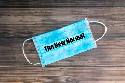 THE NEW NORMAL text with face mask on wooden background 库存照片