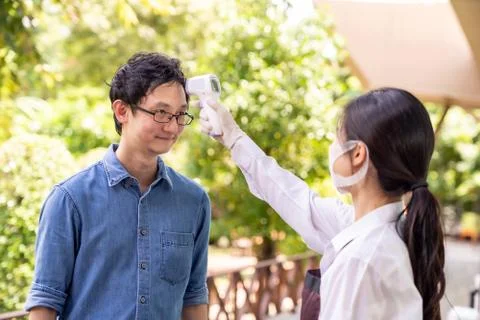 New normal Waitress take temperature customer Stock Photos