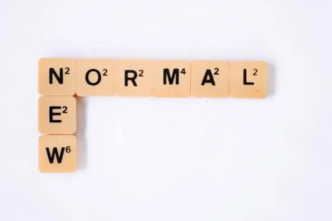New Normal word on rustic plastic tiles alphabet puzzle board game. Stock Photos