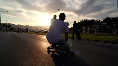 New normal, a young spanish man with a mask riding a longboard on the road 스톡 동영상 130869259