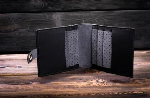 New open empty black leather wallet on rustic wood background Stock Photos
