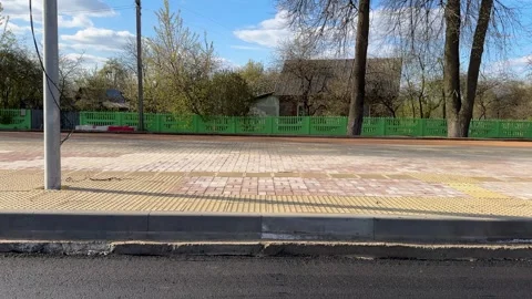 A new paved road and sidewalk with tactile paving, wooden houses Stock Footage 334067763