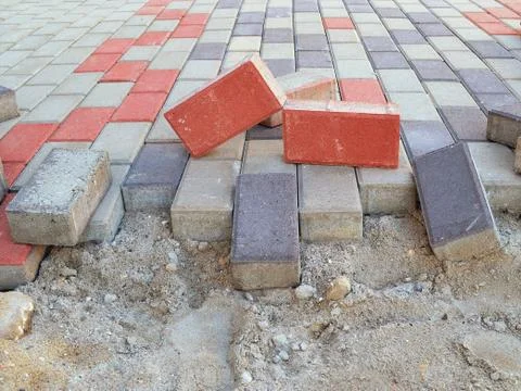 New pavement laying with rectangular paving slabs of gray, blue and red color Stock Photos