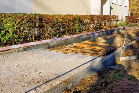 A new pedestrian path, half lined with paving slabs. Stock Photos