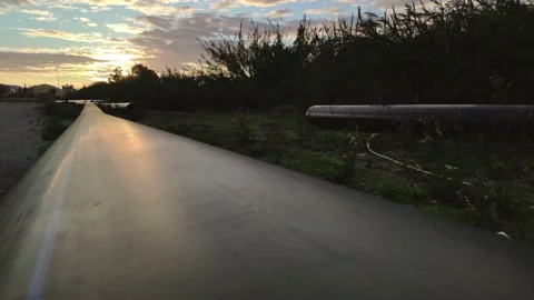 New pipes wait on the ground at sunset in suburban district Stock Footage 145299880