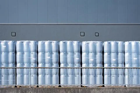 New plastic drums stacked on pallets at warehouse, industrial storage Stock Photos