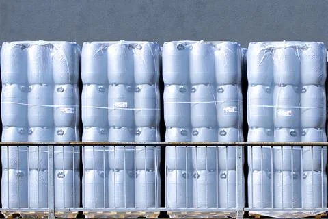 New plastic drums stacked on pallets at warehouse, industrial storage Stock Photos