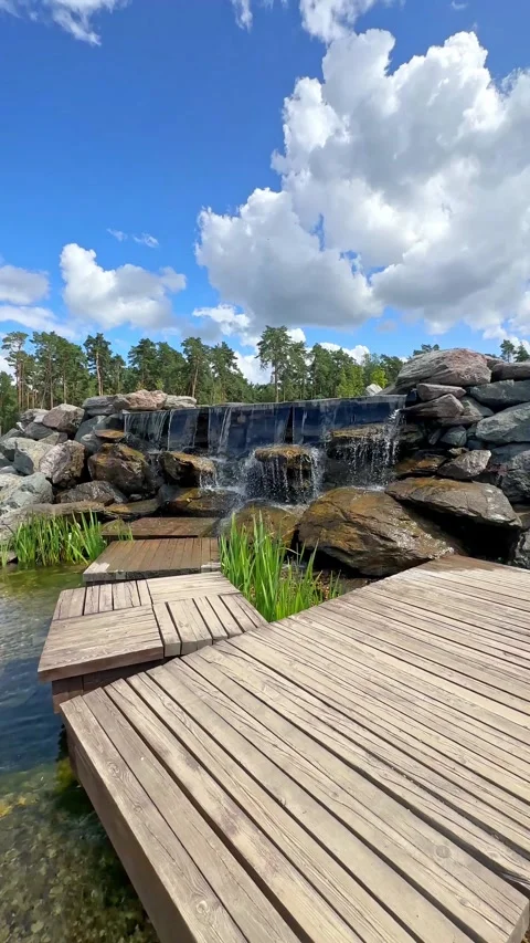  New pond with large multi-level waterfall lined with stones. Beautiful Nature.  Stock Footage 296238222