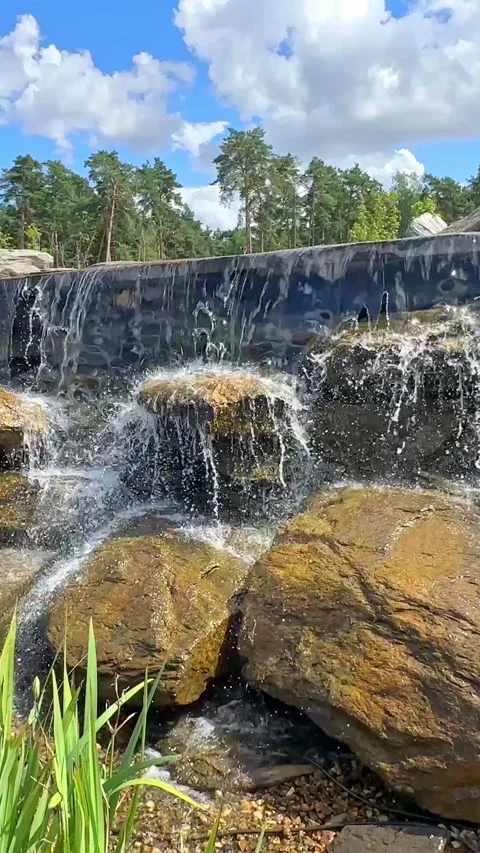  New pond with large multi-level waterfall lined with stones. Beautiful Nature.  Stock Footage 296238261