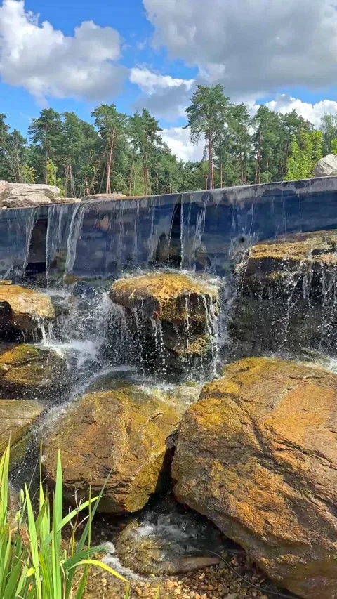  New pond with large multi-level waterfall lined with stones. Beautiful Nature.  Stock Footage 296238316