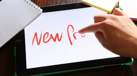 New 	project. Hands writing word on tablet at workplace Stock Footage 63139513