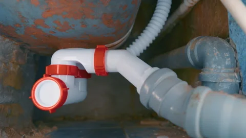 New PVC Siphon Installed Under Old Rusty Bathtub | Plumbing Repair and Bathroom Stock Footage 334615687