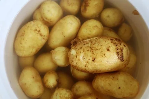 New raw Potato in the dish Stock Photos