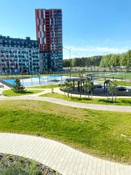 New residential complex park featuring green lawns, walking paths, playground Stock Photos