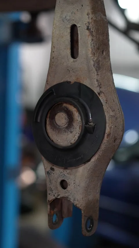 A new rubber silent block pressed into a rusty suspension arm. Stock Footage 345912178