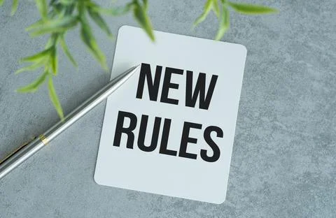 NEW RULES text on the notebook with pen on gray background Stock Photos