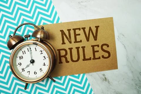New Rules text written on paper card with alarm clock on marble background Foto stock