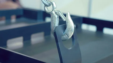 New shiny metal hook on a cable with a safety clamp, hooked on a metal structure Stock Footage 217896683
