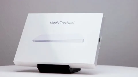 New shiny white package box of Mac magic trackpad on display stand with Stock Footage 176448352