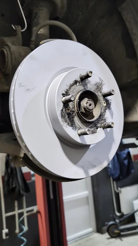 New silver brake disc mounted on vehicle hub in auto repair workshop Stock Footage 301516447
