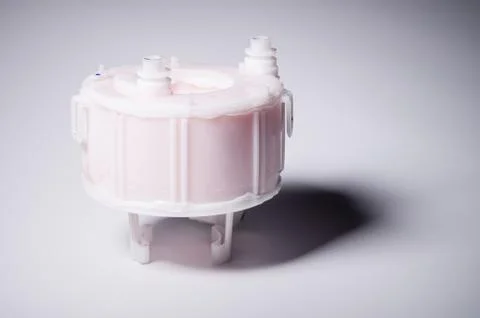 New spare part. Replaceable white plastic inner fuel filter on a gray gradient Foto stock