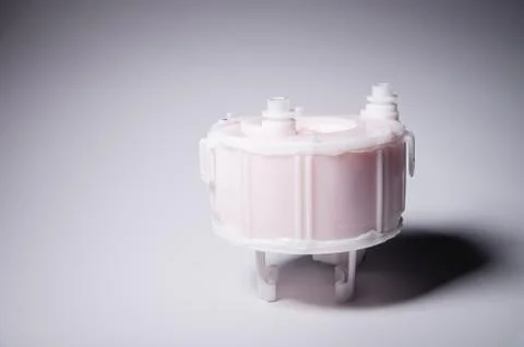 New spare part. Replaceable white plastic inner fuel filter on a gray gradient 스톡 사진