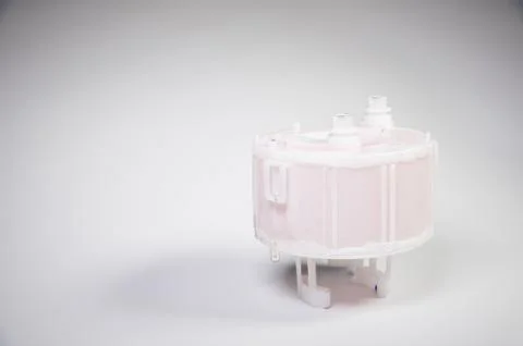 New spare part. Replaceable white plastic inner fuel filter on a gray gradient 스톡 사진