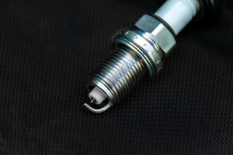 New spark plug on dark background, selective focus Stock Photos