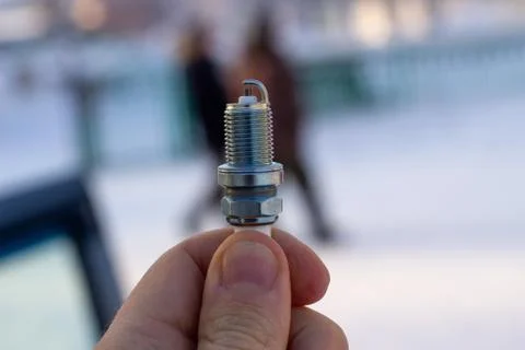 New spark plug in hand. Replacing spark plugs in the car. 스톡 사진