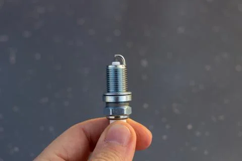 New spark plug in hand. Replacing spark plugs in the car. 스톡 사진