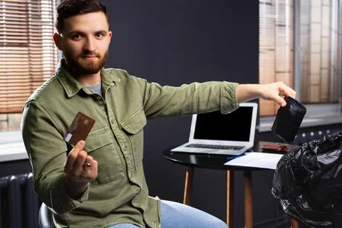 New technologies. A young man throws a wallet with money into a garbage bag and Фото