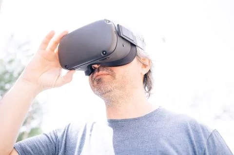 New technology worker using virtual reality glasses outside the workplace. Stock Photos
