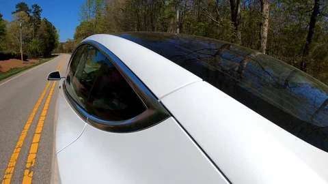 A new Tesla Model 3 drives down the road. Stock Footage 128445381